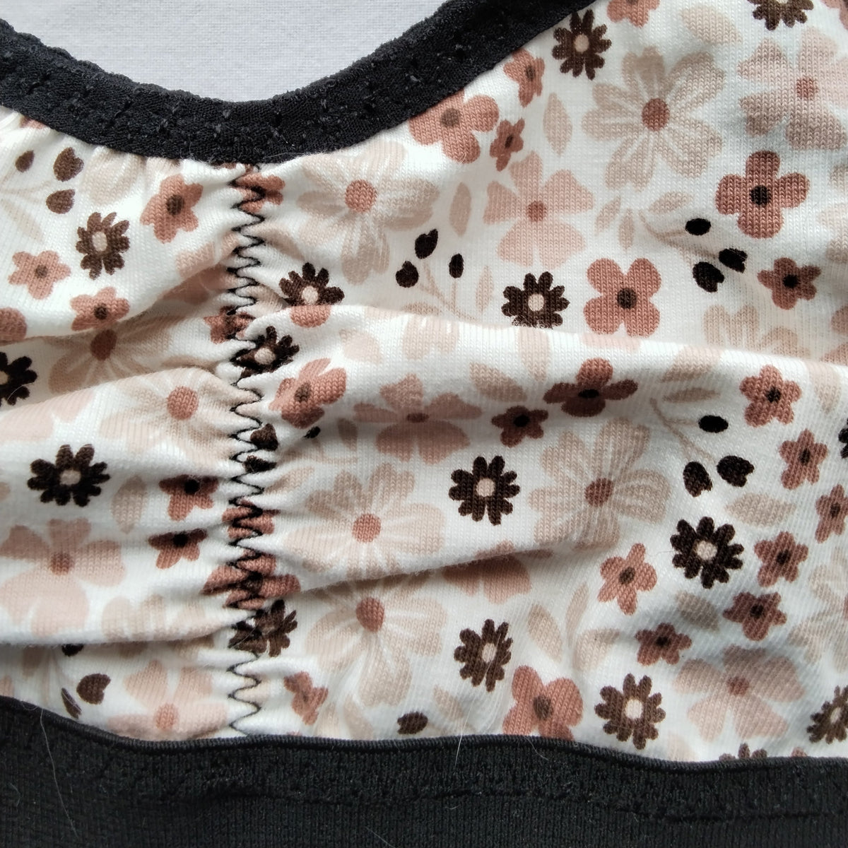 Gros plan sur le tissu semis de fleurs et la couture centrale de la brassière artisanale taille L – création Grosse Patate Création
